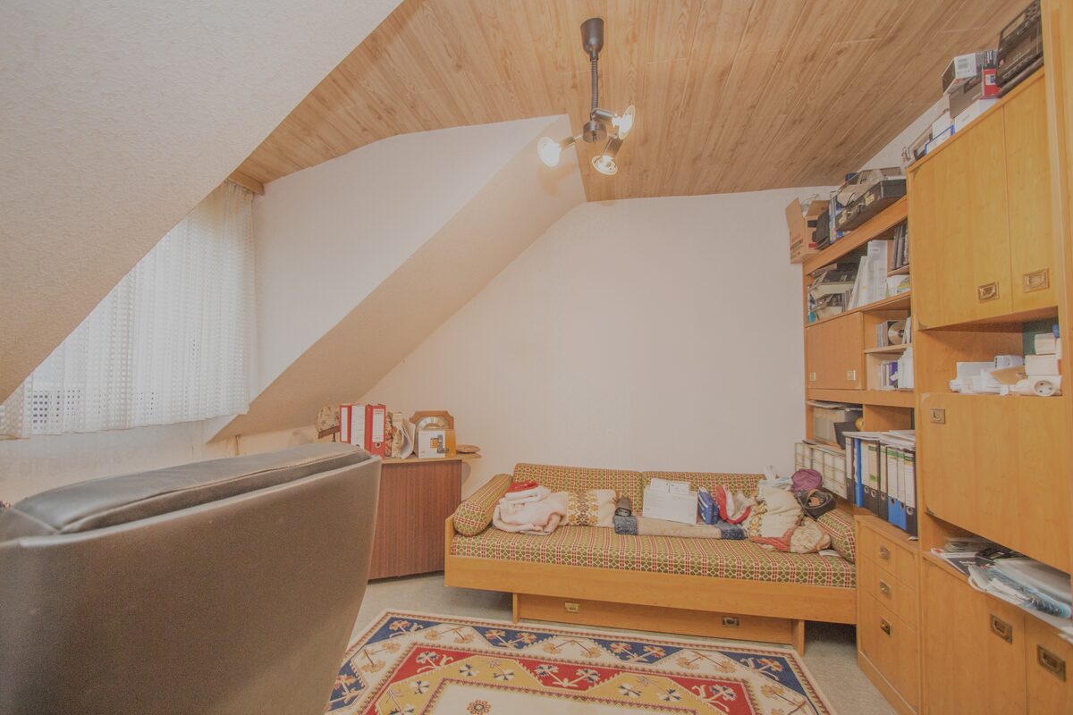 Dachzimmer vor der Entrümpelung, voll mit Möbeln und Kartons
